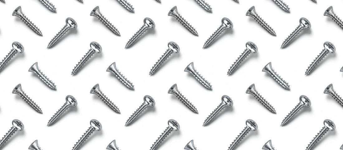 Silver flat head wood screws arranged over a white background