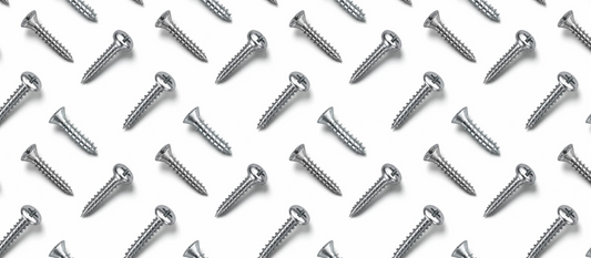 Silver flat head wood screws arranged over a white background